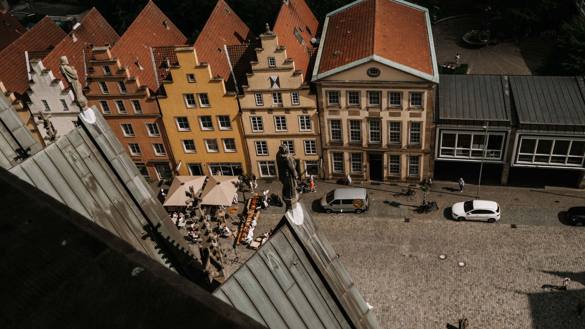 Zicht op het plein met de kleurrijke gevelhuizen en cafétafels vanaf de hoogte van de St. Mary's Church.