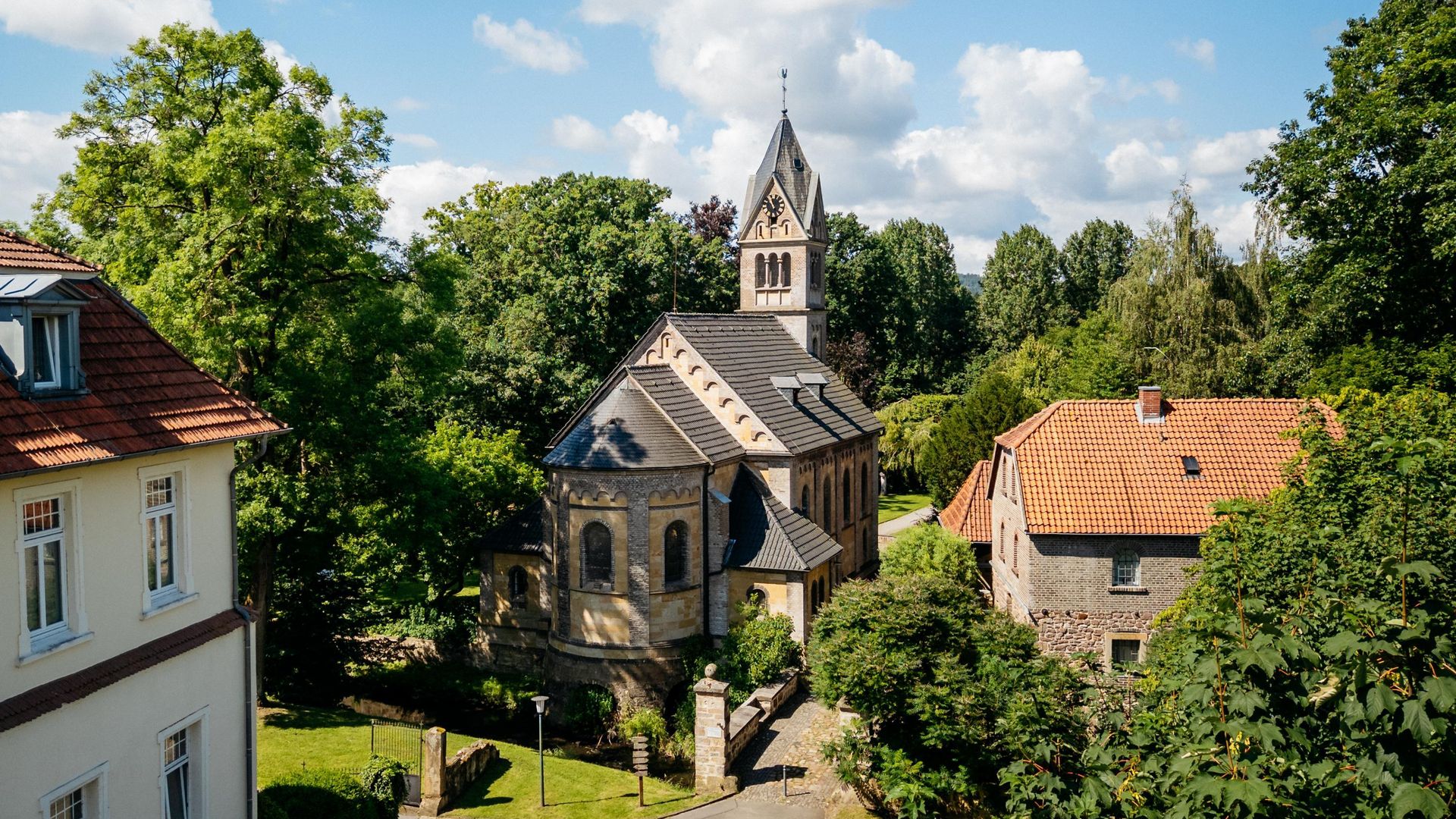 St. Urban Kirche in einem grün umgebenen Dorf bei sonnigem Wetter.