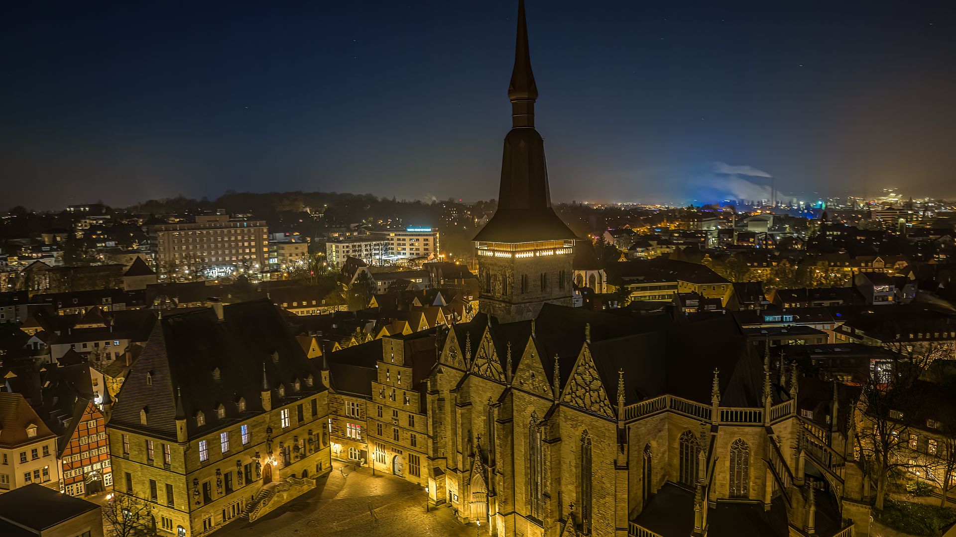 Nachtelijk uitzicht op de verlichte Sint-Martini-kerk in het centrum van Braunschweig.