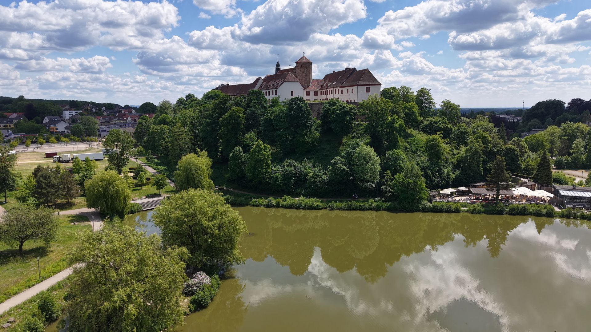 Kasteel Iburg met het Charlottensee meer op de voorgrond, genesteld in het groene landschap rond Bad Iburg.