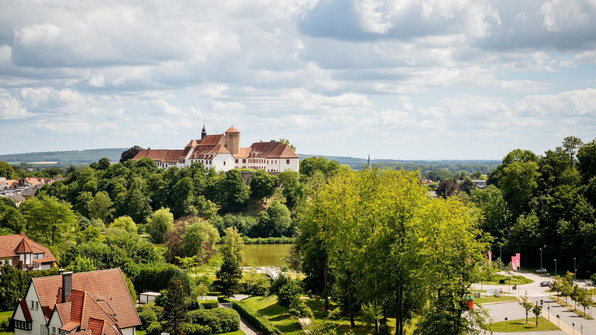 Uitzicht op een historisch kasteel op een beboste heuvel met het omliggende landschap.
