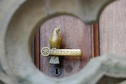 Deurgreep op het historische stadhuis van Osnabrück. Een gouden duif zit op een symbolische paal.
