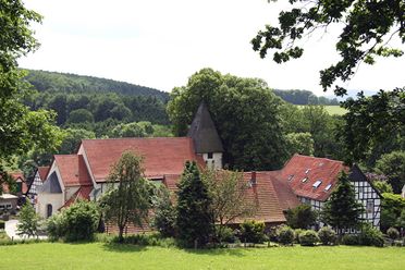 Bissendorfer Kirchburg in Holte met vakwerkgebouwen en kerktoren in een groene omgeving.